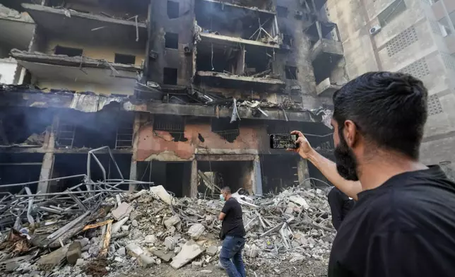 Residents check the site of an Israeli airstrike in Dahiyeh, Beirut, Lebanon, Saturday, Nov. 9, 2024. (AP Photo/Hassan Ammar)