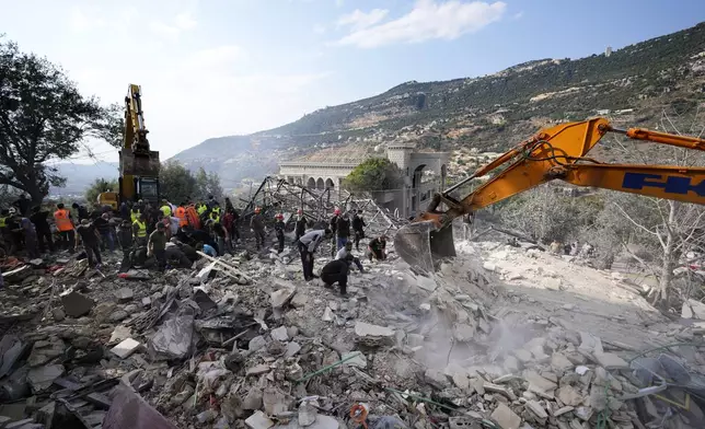 Rescue workers use excavators to remove the rubble of a destroyed house hit in an Israeli airstrike, as they search for victims in Aalmat village, northern Lebanon, Sunday, Nov. 10, 2024. (AP Photo/Hassan Ammar)