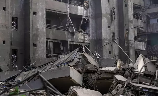 A man shouts slogans against Israel as he stands on the balcony of his damaged apartment at the site of an Israeli airstrike in Dahiyeh, Beirut, Lebanon, Friday, Nov. 1, 2024. (AP Photo/Hassan Ammar)