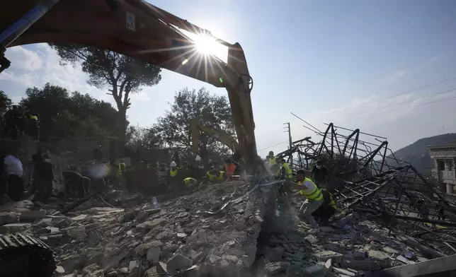 Rescue workers use an excavator to remove the rubble of a destroyed house hit in an Israeli airstrike, as they search for victims in Aalmat village, northern Lebanon, Sunday, Nov. 10, 2024. (AP Photo/Hassan Ammar)