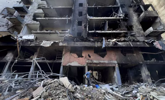 A man walks on the rubble of a building that was destroyed by an Israeli airstrike in Dahiyeh, in the southern suburb of Beirut, Lebanon, Monday, Nov. 11, 2024. (AP Photo/Hussein Malla)