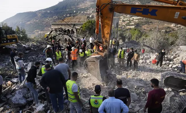 Rescue workers use an excavator to remove the rubble of a destroyed house hit in an Israeli airstrike, as they search for victims in Aalmat village, northern Lebanon, Sunday, Nov. 10, 2024. (AP Photo/Hassan Ammar)