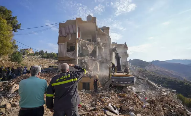 Rescue workers use excavators to remove the rubble of a destroyed building that was hit Tuesday night in an Israeli airstrike, as they search for victims in Barja, Lebanon, Wednesday, Nov. 6, 2024. (AP Photo/Hassan Ammar)