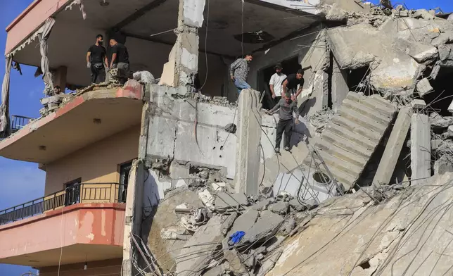 People search for victims at a destroyed building hit in an Israeli airstrike, in Ghaziyeh town, south Lebanon, Sunday, Nov. 3, 2024. (AP Photo/Mohammed Zaatari)