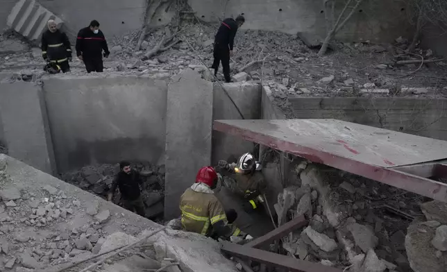 Rescue workers search for victims between the rubble of destroyed a house that was hit in an Israeli airstrike in Baalchmay village east of Beirut, Lebanon, Tuesday, Nov. 12, 2024. (AP Photo/Hassan Ammar)