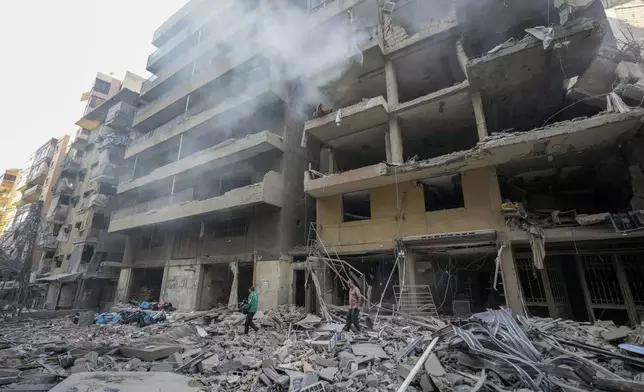 Residents check the site of an Israeli airstrike in Dahiyeh, Beirut, Lebanon , Saturday, Nov. 9, 2024. (AP Photo/Hassan Ammar)