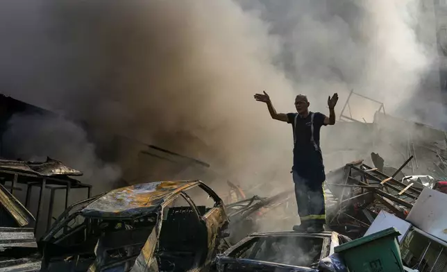 A civil defense worker gestures as smoke rises from the site of an Israeli airstrike in Dahiyeh, Beirut, Lebanon, Friday, Nov. 1, 2024. (AP Photo/Hassan Ammar)