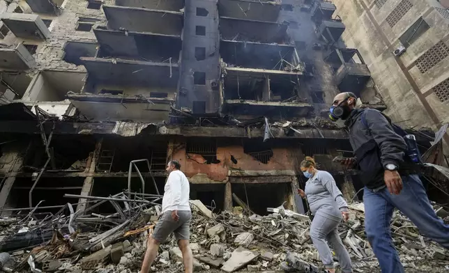 Residents check the site of an Israeli airstrike in Dahiyeh, Beirut, Lebanon, Saturday, Nov. 9, 2024. (AP Photo/Hassan Ammar)