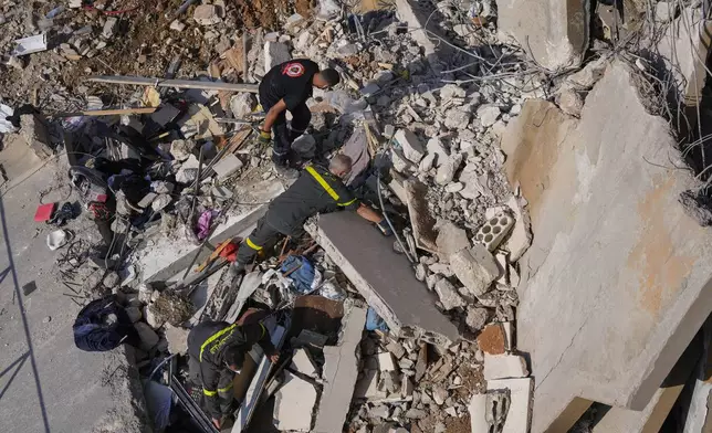 Civil defense workers search for victims in the rubble of a destroyed building hit in an Israeli airstrike on Tuesday night, in Barja, Lebanon, Wednesday, Nov. 6, 2024. (AP Photo/Hassan Ammar)