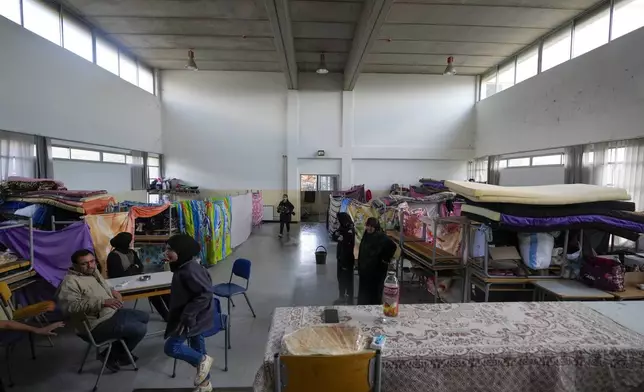 Displaced people, who fled Baalbek city and the nearby towns of Douris and Ain Bourday amid the ongoing Hezbollah-Israel war, sit at a school being used as a shelter, in Deir Al-Ahmar, east Lebanon, Thursday, Oct. 31, 2024. (AP Photo/Hassan Ammar)