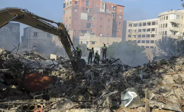 Emergency workers search for survivors at the scene of an Israeli airstrike in Tyre, southern Lebanon, Saturday, Nov. 9, 2024. (AP Photo/Mohammad Zaatari)