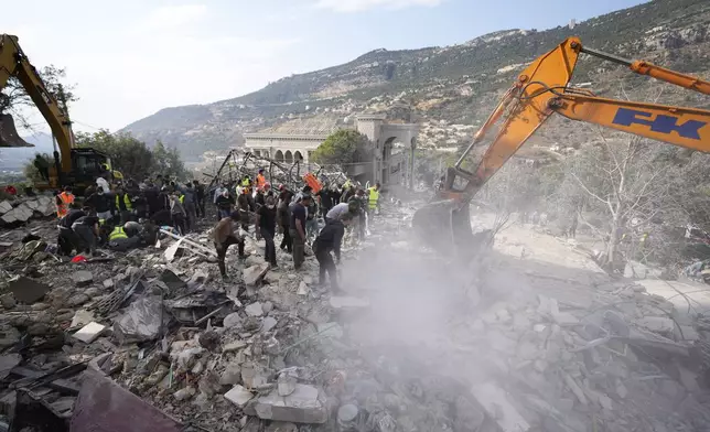 Rescue workers use excavators to remove the rubble of a destroyed house hit in an Israeli airstrike, as they search for victims in Aalmat village, northern Lebanon, Sunday, Nov. 10, 2024. (AP Photo/Hassan Ammar)