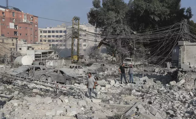 Resident check the site of an Israeli airstrike in Tyre, southern Lebanon, Saturday, Nov. 9, 2024. (AP Photo/Mohammad Zaatari)