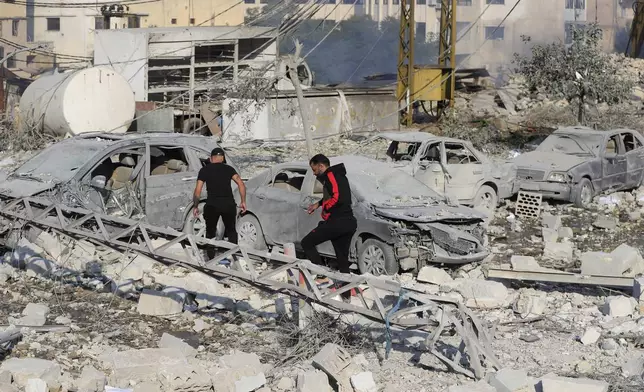 Resident check the site of an Israeli airstrike in Tyre, southern Lebanon, Saturday, Nov. 9, 2024. (AP Photo/Mohammad Zaatari)