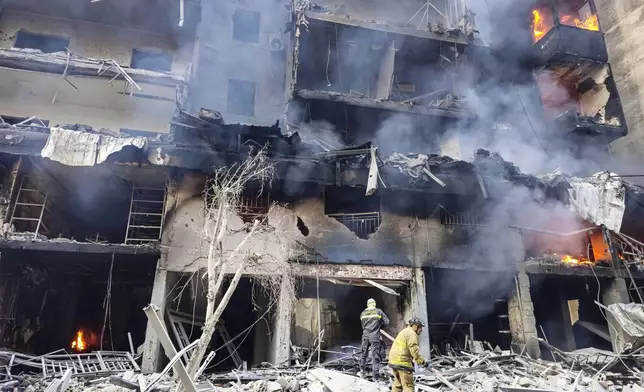 Civil defense workers extinguish a fire as smoke rises from the site of an Israeli airstrike in Dahiyeh, Beirut, Lebanon, Saturday, Nov. 9, 2024. (AP Photo/Hassan Ammar)