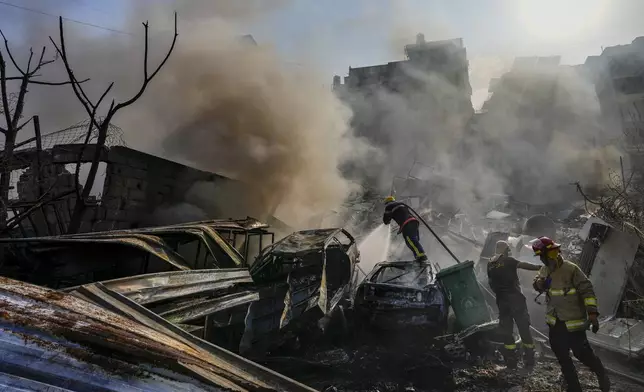 Civil defense workers extinguish a fire as smoke rises from the site of an Israeli airstrike in Dahiyeh, Beirut, Lebanon, Friday, Nov. 1, 2024. (AP Photo/Hassan Ammar)