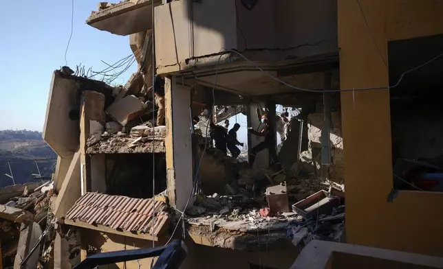 Rescue workers search for victims in the rubble of a destroyed building hit in an Israeli airstrike on Tuesday night, in Barja, Lebanon, Wednesday, Nov. 6, 2024. (AP Photo/Hassan Ammar)