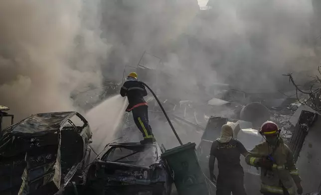 Civil defense workers extinguish a fire as smoke rises from the site of an Israeli airstrike in Dahiyeh, Beirut, Lebanon, Friday, Nov. 1, 2024. (AP Photo/Hassan Ammar)