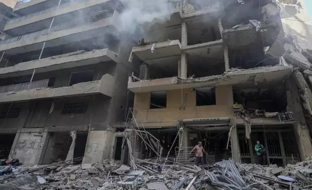 Residents check the site of an Israeli airstrike in Dahiyeh, Beirut, Lebanon , Saturday, Nov. 9, 2024. (AP Photo/Hassan Ammar)