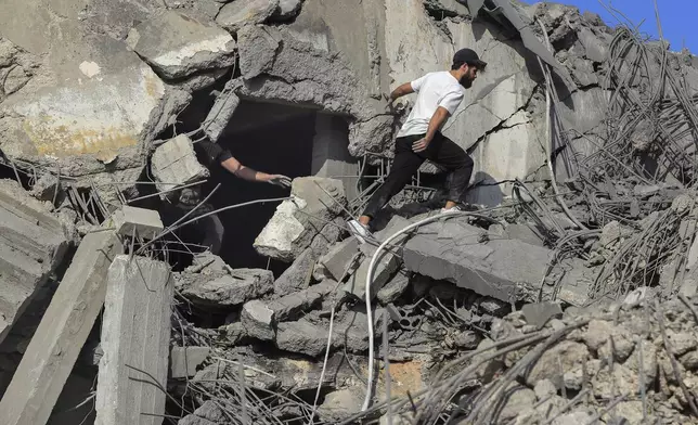 People search for victims at a destroyed building hit in an Israeli airstrike, in Ghaziyeh town, south Lebanon, Sunday, Nov. 3, 2024. (AP Photo/Mohammed Zaatari)