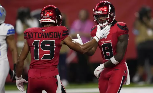 Houston Texans wide receiver John Metchie III (8) celebrates with teammate Xavier Hutchinson (19) after catching a 15-yard touchdown pass during the first half of an NFL football game against the Detroit Lions, Sunday, Nov. 10, 2024, in Houston. (AP Photo/David J. Phillip)