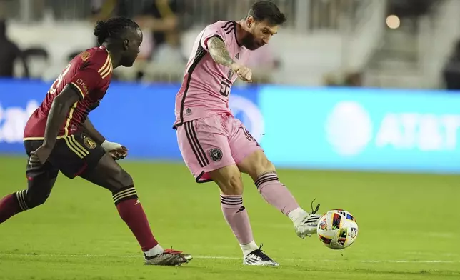 Inter Miami forward Lionel Messi (10) passes the ball as Atlanta United midfielder Tristan Muyumba (8) attempts to defend during the first half of their MLS playoff opening round soccer match, Saturday, Nov. 9, 2024, in Fort Lauderdale, Fla. (AP Photo/Rebecca Blackwell)