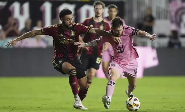 Inter Miami forward Lionel Messi (10) and Atlanta United defender Derrick Williams (3) go after the ball during the first half of an MLS playoff opening round soccer match, Saturday, Nov. 9, 2024, in Fort Lauderdale, Fla. (AP Photo/Rebecca Blackwell)