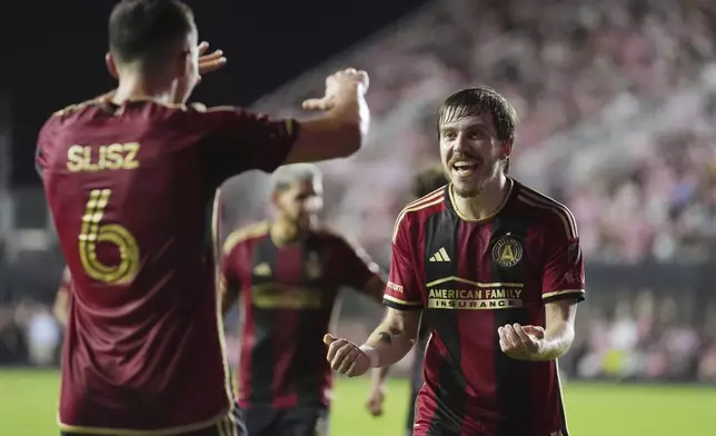 Atlanta United midfielder Bartosz Slisz (6) celebrates his goal with midfielder Saba Lobzhanidze (9) during the second half of their MLS playoff opening round soccer match against Inter Miami, Saturday, Nov. 9, 2024, in Fort Lauderdale, Fla. (AP Photo/Rebecca Blackwell)