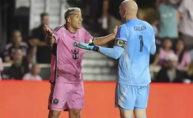 Atlanta United goalkeeper Brad Guzan (1) and Inter Miami forward Luis Suárez (9) talk on the field during the first half of an MLS playoff opening round soccer match, Saturday, Nov. 9, 2024, in Fort Lauderdale, Fla. (AP Photo/Rebecca Blackwell)