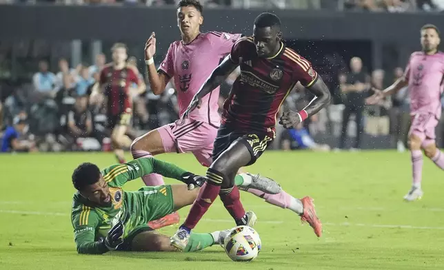 Inter Miami goalkeeper Drake Callender (1) defends Atlanta United forward Jamal ThiarÈ (29) during the first half of their MLS playoff opening round soccer match, Saturday, Nov. 9, 2024, in Fort Lauderdale, Fla. (AP Photo/Lynne Sladky)