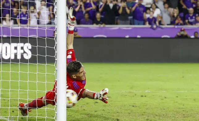 Charlotte FC goalkeeper Kristijan Kahlina misses a kick from Orlando City defender Rafael Santos during the shoot-out after the end of regulation play of Game 3 in the first round MLS Cup playoff soccer match Saturday, Nov. 9, 2024, in Orlando, Fla. (AP Photo/Kevin Kolczynski)