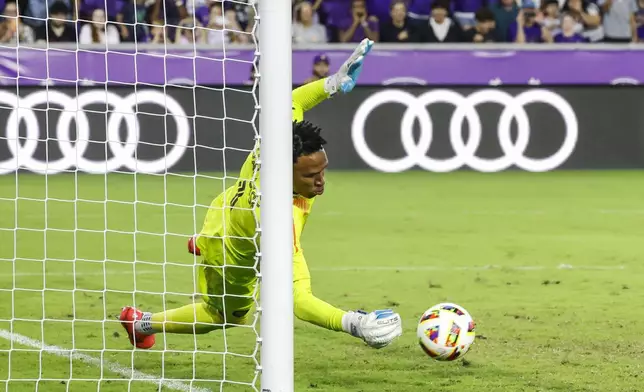 Orlando City goalkeeper Pedro Gallese, stops the ball from crossing the goal during the shoot-out against Charlotte FC after the end of regulation play of Game 3 in the first round MLS Cup playoff soccer match Saturday, Nov. 9, 2024, in Orlando, Fla. (AP Photo/Kevin Kolczynski)