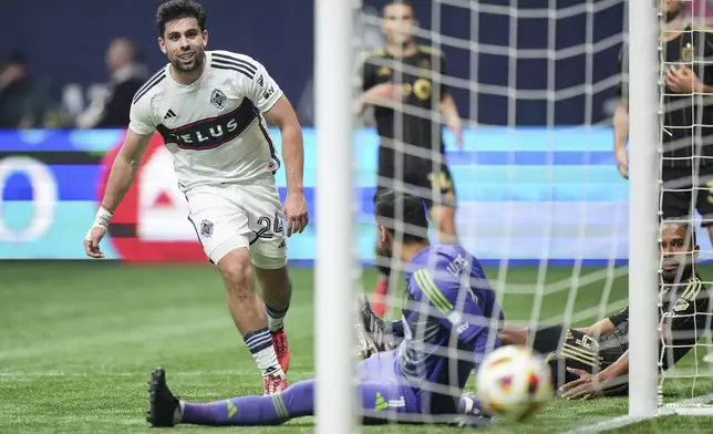 Vancouver Whitecaps' Brian White, left, scores against Los Angeles FC goalkeeper Hugo Lloris, front center, as Los Angeles FC's Eddie Segura, bottom right, looks on during the second half of Game 2 in the first round of the MLS Cup soccer playoffs in Vancouver, British Columbia, Sunday, Nov. 3, 2024. (Darryl Dyck/The Canadian Press via AP)