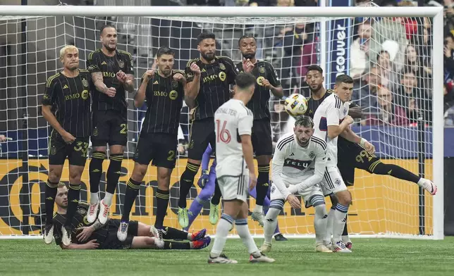 From top left to right, Los Angeles FC's Aaron Long, Maxime Chanot, Ryan Hollingshead, Olivier Giroud, Timothy Tillman, Denis Bouanga and Lewis O'Brien, bottom left, defend against a free kick by Vancouver Whitecaps' Ryan Gauld (not shown) as Whitecaps' Tristan Blackmon, second from front right, and Ranko Veselinovic, front right, watch during the first half of Game 2 in the first round of the MLS Cup soccer playoffs in Vancouver, British Columbia, Sunday, Nov. 3, 2024. (Darryl Dyck/The Canadian Press via AP)