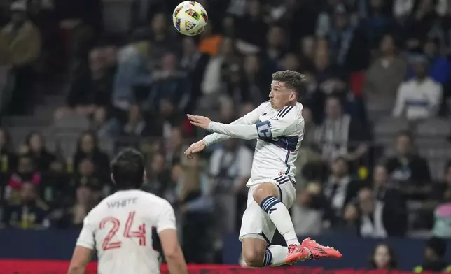 Vancouver Whitecaps' Ryan Gauld, right, jumps to get his head on the ball during the first half of Game 2 against Los Angeles FC in the first round of the MLS Cup soccer playoffs in Vancouver, British Columbia, Sunday, Nov. 3, 2024. (Darryl Dyck/The Canadian Press via AP)