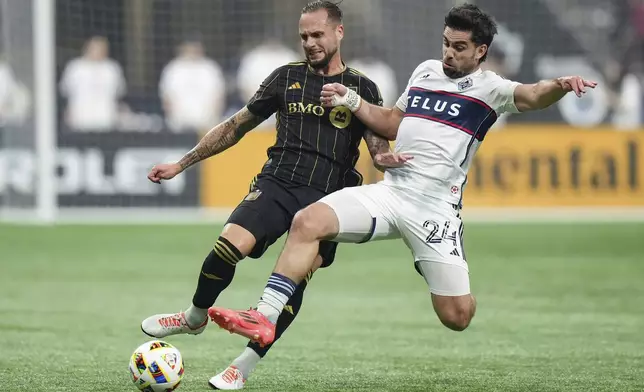 Los Angeles FC's Maxime Chanot, left, and Vancouver Whitecaps' Brian White, right, vie for the ball during the first half of Game 2 in the first round of the MLS Cup soccer playoffs in Vancouver, British Columbia, Sunday, Nov. 3, 2024. (Darryl Dyck/The Canadian Press via AP)