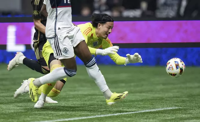 Vancouver Whitecaps goalkeeper Yohei Takaoka, right, dives to grab the ball that got past him during the first half of Game 2 against Los Angeles FC in the first round of the MLS Cup soccer playoffs in Vancouver, British Columbia, Sunday, Nov. 3, 2024. (Darryl Dyck/The Canadian Press via AP)