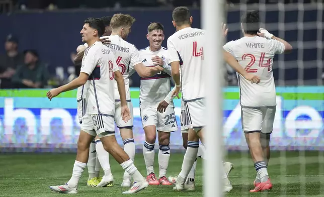 Vancouver Whitecaps' Ryan Gauld (25), Ranko Veselinovic (4), Brian White (24), Stuart Armstrong, back left, and Alessandro Schopf (8) celebrate after White's goal against Los Angeles FC during the second half of Game 2 in the first round of the MLS Cup soccer playoffs in Vancouver, British Columbia, Sunday, Nov. 3, 2024. (Darryl Dyck/The Canadian Press via AP)