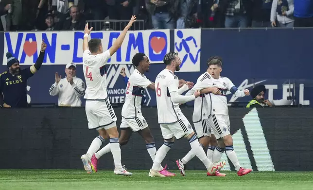 Fromleft to right, Vancouver Whitecaps' Ranko Veselinovic, Ali Ahmed, Tristan Blackmon, Sebastian Berhalter, back right, and Ryan Gauld celebrate after Gauld's goal against Los Angeles FC during the first half of Game 2 in the first round of the MLS Cup soccer playoffs in Vancouver, British Columbia, Sunday, Nov. 3, 2024. (Darryl Dyck/The Canadian Press via AP)