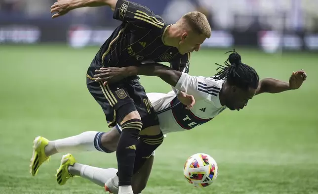 Los Angeles FC's Mateusz Bogusz, front left, knocks Vancouver Whitecaps' Sam Adekugbe off the ball during the first half of Game 2 in the first round of the MLS Cup soccer playoffs in Vancouver, British Columbia, Sunday, Nov. 3, 2024. (Darryl Dyck/The Canadian Press via AP)