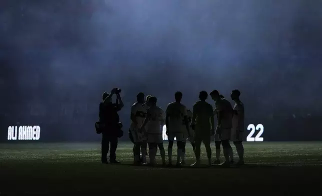 Vancouver Whitecaps players are silhouetted as smoke from pyrotechnics hangs in the air before Game 2 against Los Angeles FC in the first round of the MLS Cup soccer playoffs in Vancouver, British Columbia, Sunday, Nov. 3, 2024. (Darryl Dyck/The Canadian Press via AP)