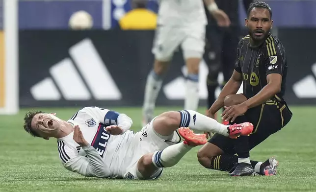 Vancouver Whitecaps' Ryan Gauld, left, reacts after being tackled by Los Angeles FC's Eddie Segura during the second half of a first-round MLS Cup playoffs soccer match, in Vancouver, British Columbia. Sunday, Nov. 3, 2024. (Darryl Dyck/The Canadian Press via AP)