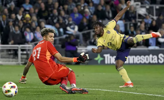 Real Salt Lake midfielder Emeka Eneli, right, scores a goal on Minnesota United goalkeeper Dayne St. Clair (97) during the second half of a first-round soccer match of the MLS Cup playoffs in St. Paul, Minn., Saturday, Nov. 2, 2024. (AP Photo/Ellen Schmidt)