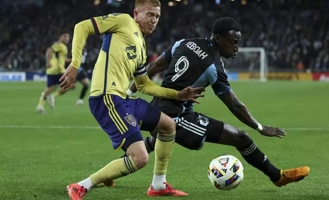 Real Salt Lake defender Justen Glad, left, loses the ball to Minnesota United forward Kelvin Yeboah (9) during the first half of a first-round soccer match of the MLS Cup playoffs in St. Paul, Minn., Saturday, Nov. 2, 2024. (AP Photo/Ellen Schmidt)