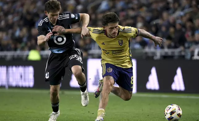 Minnesota United midfielder Will Trapp (20) and Real Salt Lake midfielder Diego Luna (8) vie for the ball during the second half of a first-round soccer match of the MLS Cup playoffs in St. Paul, Minn., Saturday, Nov. 2, 2024. (AP Photo/Ellen Schmidt)