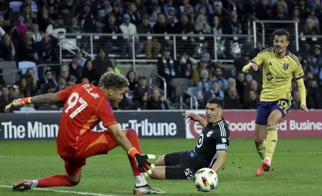 Minnesota United goalkeeper Dayne St. Clair (97) and defender Michael Boxall, center, thwart an attempted goal by Real Salt Lake midfielder Diogo Gonçalves (10) during the second half of a first-round soccer match of the MLS Cup playoffs in St. Paul, Minn., Saturday, Nov. 2, 2024. (AP Photo/Ellen Schmidt)