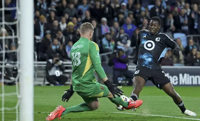 Minnesota United defender Devin Padelford (2) attempts a goal while Real Salt Lake goalkeeper Zac MacMath (18) saves the ball during the first half of a first-round soccer match of the MLS Cup playoffs in St. Paul, Minn., Saturday, Nov. 2, 2024. (AP Photo/Ellen Schmidt)