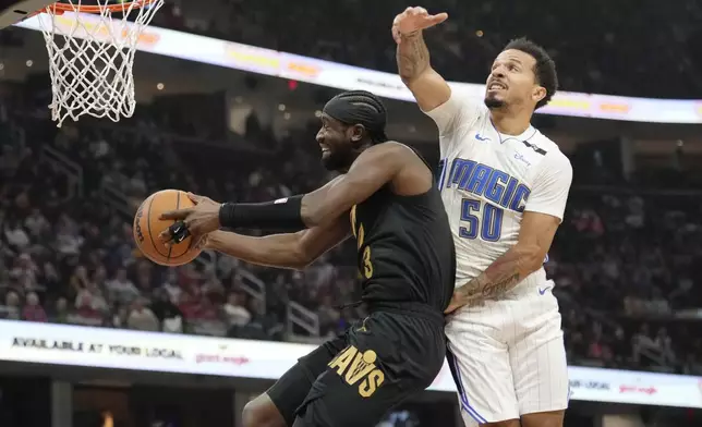 Cleveland Cavaliers guard Caris LeVert, left, goes to the basket past Orlando Magic guard Cole Anthony (50) in the first half of an NBA game, Friday, Nov. 1, 2024, in Cleveland. (AP PhotoSue Ogrocki)