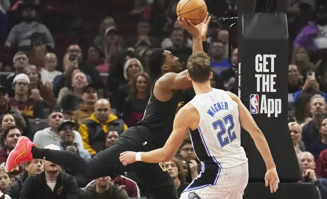 Cleveland Cavaliers guard Donovan Mitchell, left, goes to the basket past Orlando Magic forward Franz Wagner (22) in the first half of an NBA game, Friday, Nov. 1, 2024, in Cleveland. (AP PhotoSue Ogrocki)