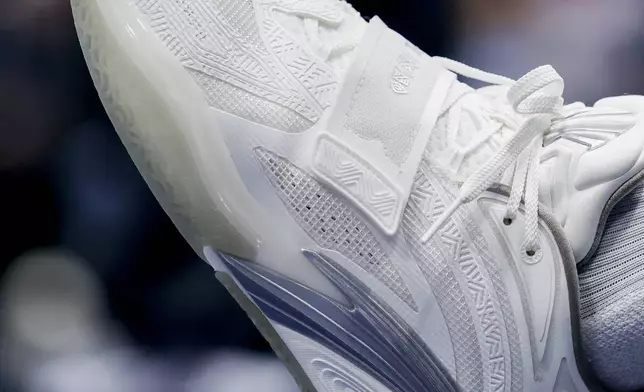 Dallas Mavericks center Daniel Gafford sits courtside with "Philippians 4:13" written on his sneakers before an NBA basketball game against the Orlando Magic, Sunday, Nov. 3, 2024, in Dallas. (AP Photo/Gareth Patterson)